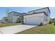 Modern two-story home with a long driveway, lush lawn, and attached two-car garage at 2378 Broadbrook Dr, St Cloud, FL 34771