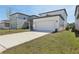 Modern two-story home with a long driveway, lush lawn, and attached two-car garage at 2378 Broadbrook Dr, St Cloud, FL 34771