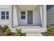 Inviting front porch with gray door and white pillars, framed by manicured landscaping at 2378 Broadbrook Dr, St Cloud, FL 34771