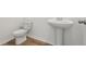 Bright bathroom featuring a pedestal sink and toilet on wood-look flooring at 339 Conway Ave, St Cloud, FL 34771