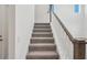 Carpeted staircase with white railing and stained wood trim leading to upper level at 339 Conway Ave, St Cloud, FL 34771