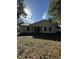The back exterior reveals a well-maintained yard and a home designed for seamless indoor-outdoor living at 911 Pine Ave, Mount Dora, FL 32757