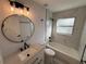 Bathroom featuring marble-style tiling, modern fixtures, and a bathtub with shower combo at 911 Pine Ave, Mount Dora, FL 32757