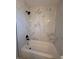Bathroom featuring a clean white bathtub with a new shower and a marble style tile surround at 911 Pine Ave, Mount Dora, FL 32757