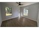 Bright bedroom with wood-look flooring, ceiling fan, and windows offering natural light at 911 Pine Ave, Mount Dora, FL 32757