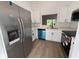New Kitchen with stainless steel appliances, white cabinets, and view to the back yard at 911 Pine Ave, Mount Dora, FL 32757