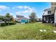 Large, grassy backyard with a view of a detached garage and neighboring homes at 9133 Smithies St, Orlando, FL 32827