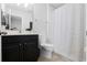 Modern bathroom with a black vanity, white toilet, and stylish shower curtain at 9133 Smithies St, Orlando, FL 32827