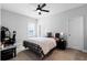 Comfortable bedroom featuring a bed with a fan, desk, and a bedside table with a lamp at 9133 Smithies St, Orlando, FL 32827