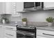 Close-up of kitchen showcasing granite countertops, stainless steel appliances, and modern cabinetry at 9133 Smithies St, Orlando, FL 32827