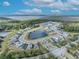 An aerial view showcases a modern residential community nestled around a serene lake at 7409 Wing Span Way, Harmony, FL 34773