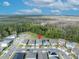 An aerial view pinpoints a single-Gathering home in a community with lush greenery and solar panels at 7409 Wing Span Way, Harmony, FL 34773