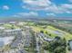 Aerial view shows a vibrant community with pool, tennis courts, and a lush golf course at 7409 Wing Span Way, Harmony, FL 34773