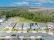 An aerial view shows houses on a street in a verdant community, some with solar panels at 7409 Wing Span Way, Harmony, FL 34773