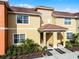 Well-maintained townhouse with a red tile roof, neutral paint, and manicured landscaping at 8939 Bismarck Palm Rd, Kissimmee, FL 34747