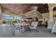Outdoor tiki bar featuring a thatched roof, bar seating, and tables with chairs by the pool at 8939 Bismarck Palm Rd, Kissimmee, FL 34747