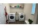 Bright laundry room with washer, dryer, and shelving at 9271 Patrimonio Loop, Windermere, FL 34786