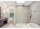 Bright bathroom featuring a sleek shower with a glass partition and a soaking tub, illuminated by a skylight at 10214 Chiltern Garden Dr, Orlando, FL 32827