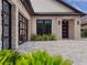 Close-up of the home's facade, highlighting the stone accents, dark-framed windows, and beautifully landscaped entryway at 10214 Chiltern Garden Dr, Orlando, FL 32827