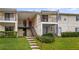 Inviting condo featuring stairs leading to a covered entrance, neutral siding, and lush landscaping around the building's base at 314 Cherokee Ct # H, Altamonte Springs, FL 32701