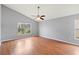 Bedroom showcases wood floors, a ceiling fan, and a large window at 4731 Summerbridge Cir, Leesburg, FL 34748