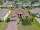 Aerial view of a home featuring a well-manicured lawn, mature palms, and a brick-paved driveway at 4731 Summerbridge Cir, Leesburg, FL 34748
