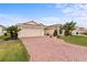 Charming home with a brick driveway, two-car garage, and well-manicured landscaping at 4731 Summerbridge Cir, Leesburg, FL 34748