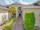 Close up of a front walkway with beautiful garden leading to an elegant front door and covered entryway at 4731 Summerbridge Cir, Leesburg, FL 34748