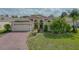 Inviting home exterior with a brick driveway, lush lawn, and a two-car garage, creating great curb appeal at 4731 Summerbridge Cir, Leesburg, FL 34748