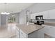 Open kitchen with white cabinets, granite counters, and an adjacent living area with sliding glass doors at 4731 Summerbridge Cir, Leesburg, FL 34748