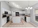 Bright kitchen featuring white cabinetry, a center island, and black appliances under a vaulted ceiling at 4731 Summerbridge Cir, Leesburg, FL 34748