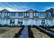 Modern three-story townhome with gray and white siding, and a brick walkway at 592 Pothos St, Apopka, FL 32703