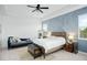 Calm bedroom with a blue accent wall, king bed, modern nightstands, and natural light from two windows at 6115 Claystone Way, Mount Dora, FL 32757