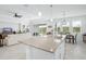 Modern kitchen with an island bar and sink, open to the living room, and a dining space with outdoor view at 6115 Claystone Way, Mount Dora, FL 32757