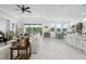 Bright open-concept living space with contemporary furnishings, light tile floors, and a seamless flow to the outdoors at 6115 Claystone Way, Mount Dora, FL 32757