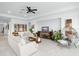 Spacious living room with a modern design, featuring comfortable sofas, stylish decor, and a ceiling fan at 6115 Claystone Way, Mount Dora, FL 32757