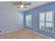 Bedroom with light blue walls, two windows, and ceiling fan at 9355 Westmorely St, Groveland, FL 34736