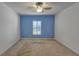 Simple bedroom with a ceiling fan and blue accent wall at 9355 Westmorely St, Groveland, FL 34736