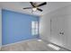 Light blue accent wall bedroom with white trim and ceiling fan at 9355 Westmorely St, Groveland, FL 34736