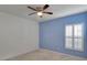 Bedroom with blue accent wall, window with shutters, and ceiling fan at 9355 Westmorely St, Groveland, FL 34736