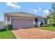 Two-car garage and a well-manicured lawn at 9355 Westmorely St, Groveland, FL 34736