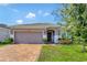 Single-story house with a two-car garage and brick paver driveway at 9355 Westmorely St, Groveland, FL 34736