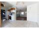 Galley kitchen, complete with white appliances, wood cabinetry and light-colored tile flooring, open to living room at 1603 Doreen Ave, Ocoee, FL 34761