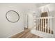 Light-filled hallway with stairs and a circular mirror at 1651 Common Way Rd, Orlando, FL 32814