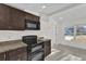 Modern kitchen with dark brown cabinets, granite countertops, and black appliances at 2341 Hadley St, Deltona, FL 32738