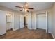 Bedroom with ceiling fan, wood-like floors, and en-suite bathroom at 1307 Pine Lake Rd, Orlando, FL 32808
