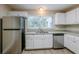 Modern kitchen with white cabinets, granite counters, and stainless steel appliances at 1307 Pine Lake Rd, Orlando, FL 32808