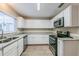 Modern kitchen with white cabinets, granite counters, and stainless steel appliances at 1307 Pine Lake Rd, Orlando, FL 32808