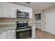 Modern kitchen with white cabinets, granite counters, and stainless steel appliances at 1307 Pine Lake Rd, Orlando, FL 32808