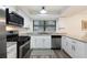 Well-lit kitchen with granite countertops, modern appliances, white cabinets, and wood look flooring at 1422 Tierra Cir, Winter Park, FL 32792